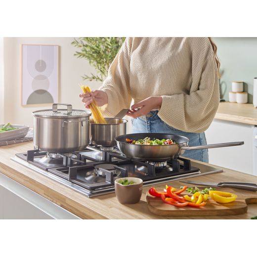 Bosch Series 6 PCP6A5I90 58cm Gas Hob - Stainless Steel - person cooking on hob