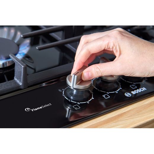 Bosch Series 6 PCP6A6I90 58cm Gas Hob - Black - person using dial shot
