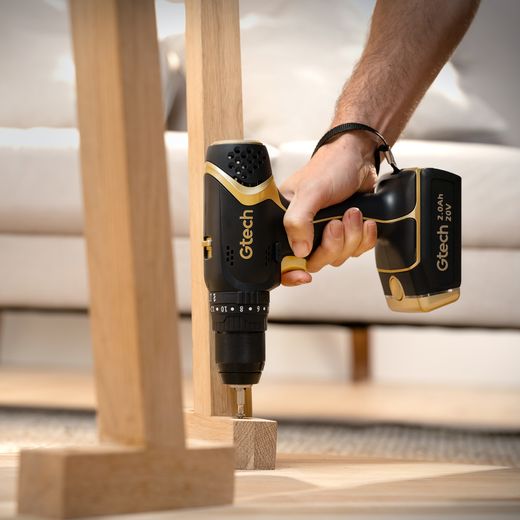 Gtech 1-12-030 Tool Black / Gold - Person using drill on table leg 
