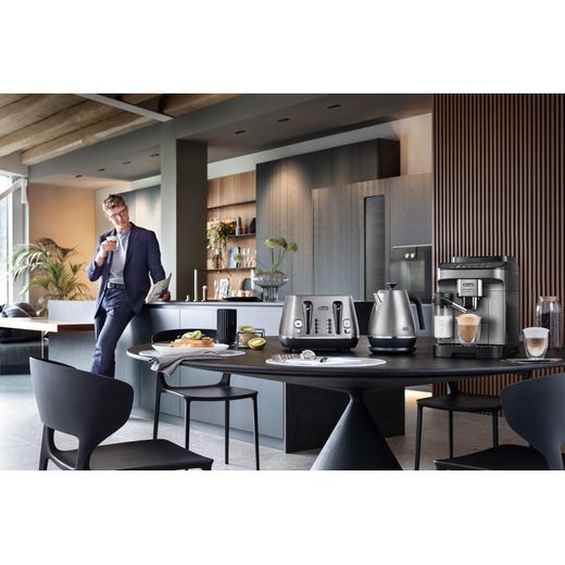 De'Longhi Magnifica Evo ECAM290.83.TB Bean to Cup Coffee Machine - Black Titanium - Coffee machine on table in room next to kettle and toaster