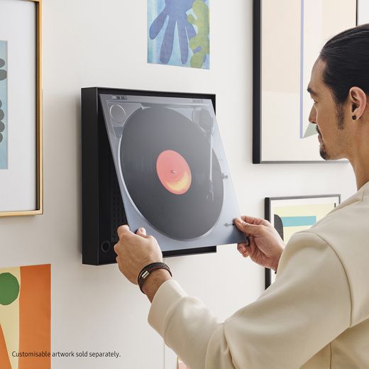 Samsung Music Frame Wireless Speaker - Black - Person putting speaker on wall shot 
