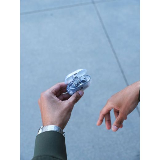 Beats Studio Buds + True Wireless Noise Cancelling In-Ear Headphones - Transparent - Closeup hands holding open case on street