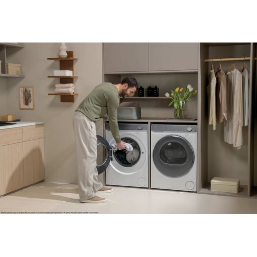 Haier X7 HW100-B14367U-UK 10kg Washing Machine with 1400 rpm - White - man using machine machine in utility room shot