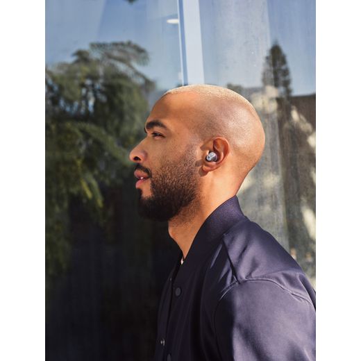 Beats Studio Buds + True Wireless Noise Cancelling In-Ear Headphones - Transparent - Man wearing headphones on street