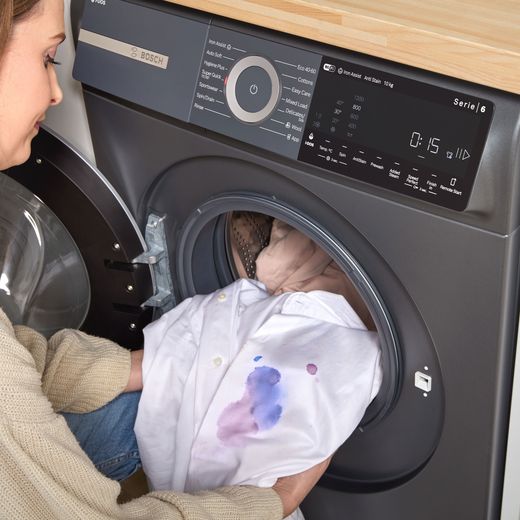Bosch Series 6 i-Dos WGH254ARGB 10kg WiFi Connected Washing Machine with 1400 rpm - Graphite - person loading machine shot