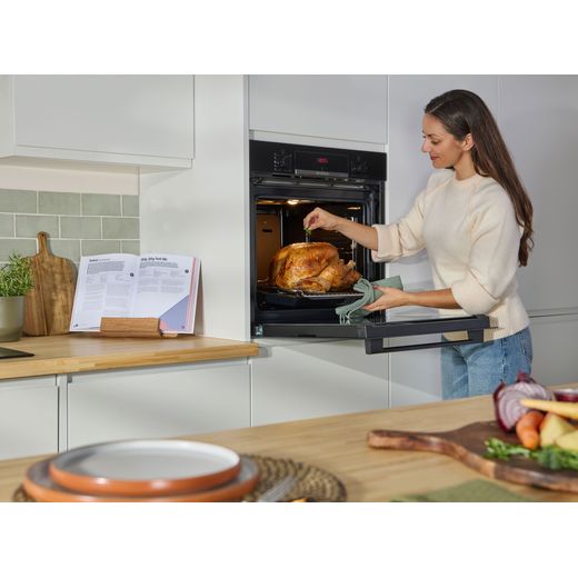 Bosch Series 4 HQA534BB3B Built In Electric Single Oven - Black - women cooking chicken in oven