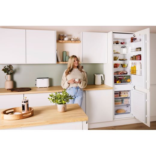 Bosch Series 2 KIN96NSE0G 194cm High 60/40 Integrated Fridge Freezer with Sliding Door Fixing Kit - White - Women in kitchen with fridge door open shot