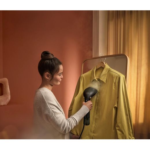 Philips 7000 series STH7060/86 Handheld Garment Steamer - Black / Gold - person steaming shirt shot