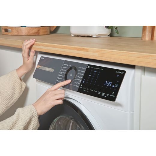 Bosch Series 6 i-Dos WGH254A0GB 10kg WiFi Connected Washing Machine with 1400 rpm - White - person using control panel shot