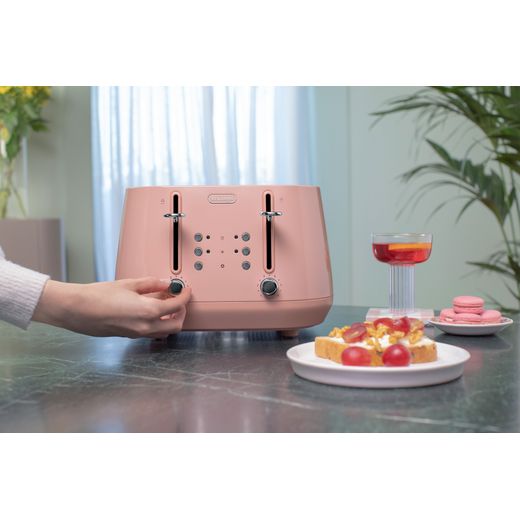 De'Longhi Eclettica CTY4003.PK 4 Slice Toaster - Pink - Person using toaster on table shot