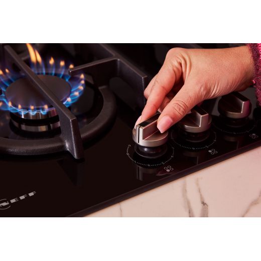 NEFF N70 T26PIP4S0 59cm Gas Hob - Black - person using dial shot