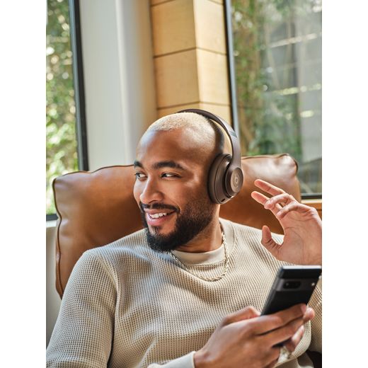 Beats Headphones - Deep Brown - Man sat on chair wearing headphone shot