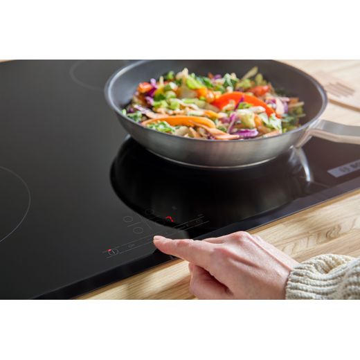 Bosch Series 4 PIE631BB5E 59cm Induction Hob - Black - person using control panel shot