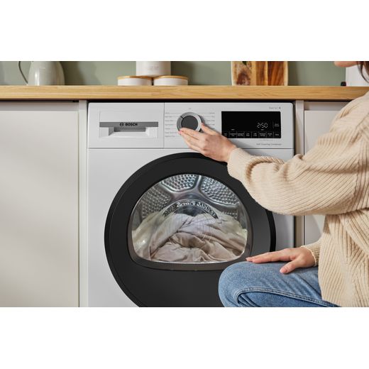 Bosch Series 6 WQG24502GB 9Kg Heat Pump Tumble Dryer - White - person using machine shot