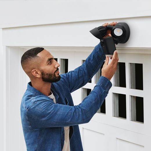 Ring Floodlight Cam Wired Plus Full HD 1080p Smart Home Security Camera - Black - Man installing camera on wall shot