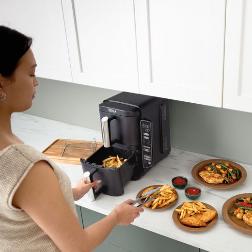 Ninja Double Stack XL SL300UK - Grey - Air fryer with chips in basket and surrounded by cooked food