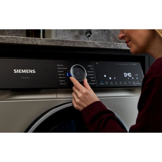 Siemens IQ-500 WQ46H2DXGB 9Kg Heat Pump Tumble Dryer - Silver  - person using tumble dryer