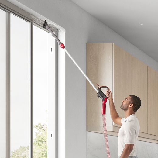 Dyson Ball Animal Origin Upright Vacuum Cleaner - Man using extendable attachment clean patio door shot 