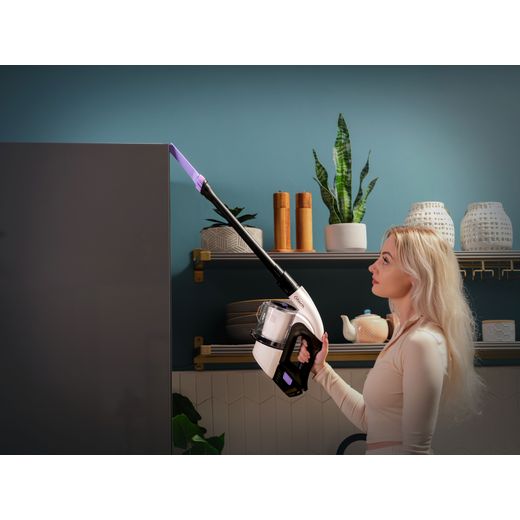 Gtech Multi Platinum 1-03-274 Cordless Vacuum Cleaner with up to 30 Minutes Run Time - Silver / Black - Women hoovering top of fridge