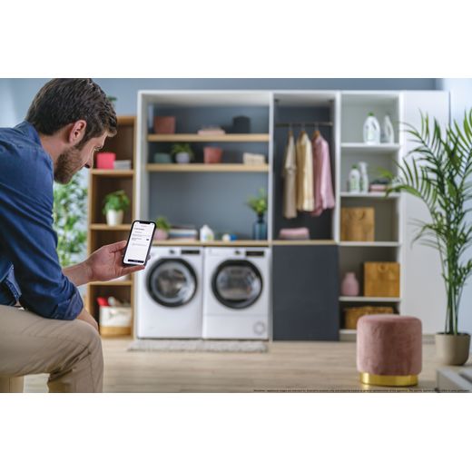 Hoover H-DRY 350 HRE H9N2TBE-80 Wifi Connected 9Kg Heat Pump Tumble Dryer - White - Person in room with washing machine shot