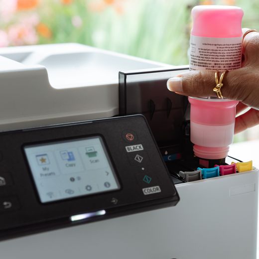 Canon MAXIFY GX2050 Wireless Inkjet Printer - White - Close up person using printer shot