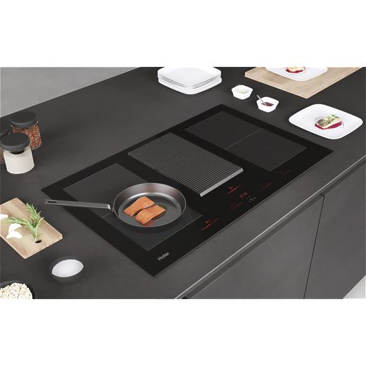 Haier 33803037 83cm Induction Hob - Black - Pan on hob cooking fish shot