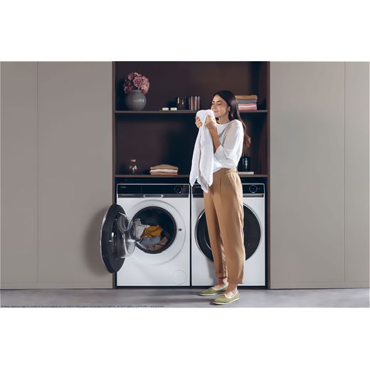 Haier HW110-BD14397U1 11kg Washing Machine with 1400 rpm - White - Women smelling fresh clothes from machine shot