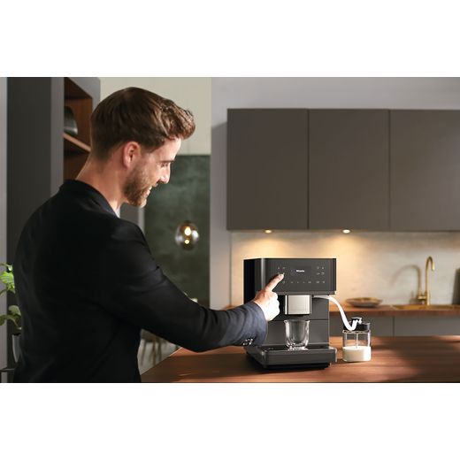 Miele 11590240 Coffee Machines Graphite Grey Pearl Finish - Man touching coffee machine control panel