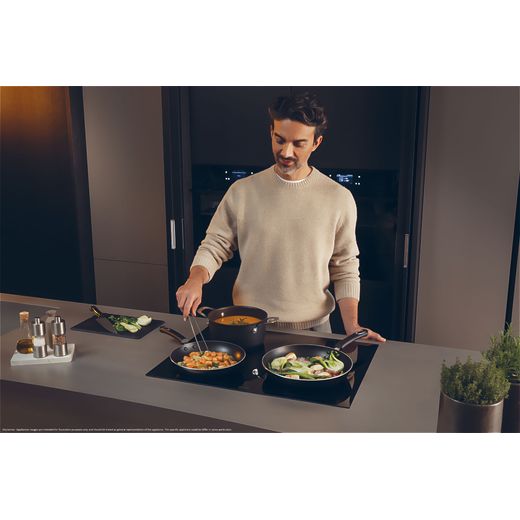 Haier HAMTB86IRCS Induction Hob - Black - man cooking food on hob shot