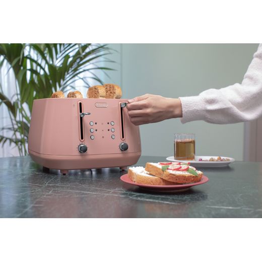 De'Longhi Eclettica CTY4003.PK 4 Slice Toaster - Pink - Person using toaster on table shot