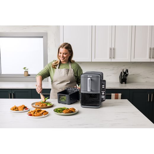 Ninja Foodi Max Dual Zone SL400UK - Black - Women cooking in kitchen with air fryer shot