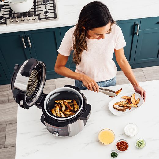Ninja Foodi Max 15-in-1 SmartLid 7.5 Litre Multi Cooker - Stainless Steel / Black - Women in modern kitchen preparing a meal