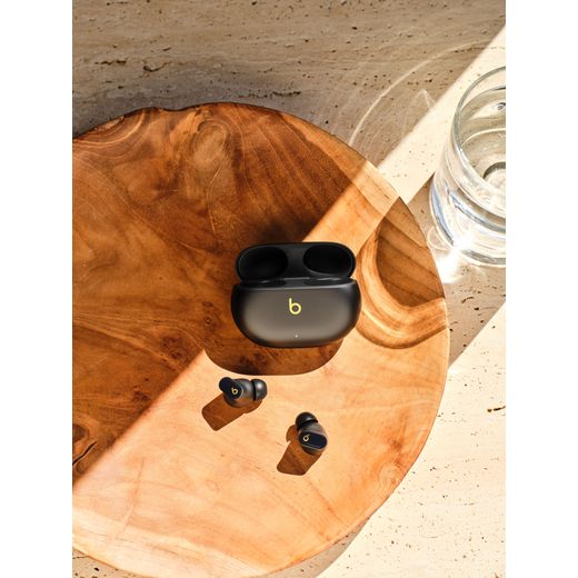 Beats Studio Buds + True Wireless Noise Cancelling In-Ear Headphones - Black / Gold - Headphones and case on table