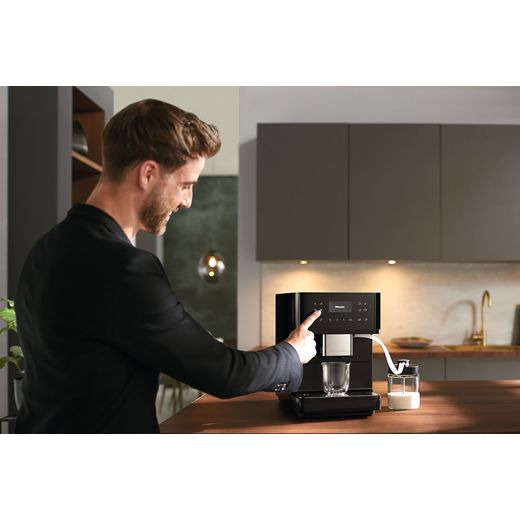Miele CM6560 Coffee Machines Obsidian Black Pearl Finish - Man touching coffee machine control panel