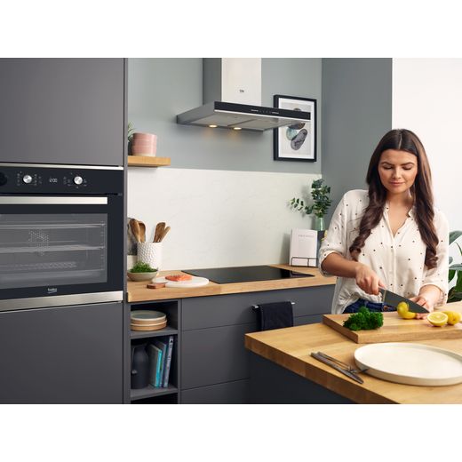Beko HII64201MT 58cm Induction Hob - Black - Lady chopping vegetables in modern kitchen, hob in the background