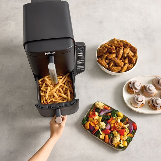 Ninja Double Stack XL SL300UK - Grey - Air fryer with chips in basket and surrounded by cooked food