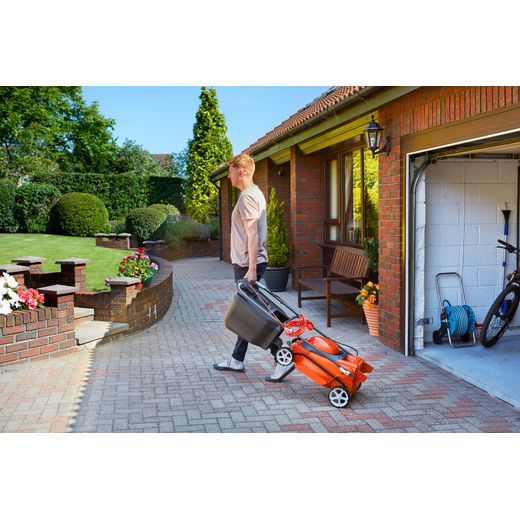 Flymo EasiStore 380R Corded Lawn Mower - Sunset Orange - person carrying mower shot