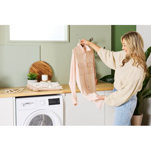 Bosch Series 4 WTH85225GB 8Kg Heat Pump Tumble Dryer - White - Women looking at shirt shot