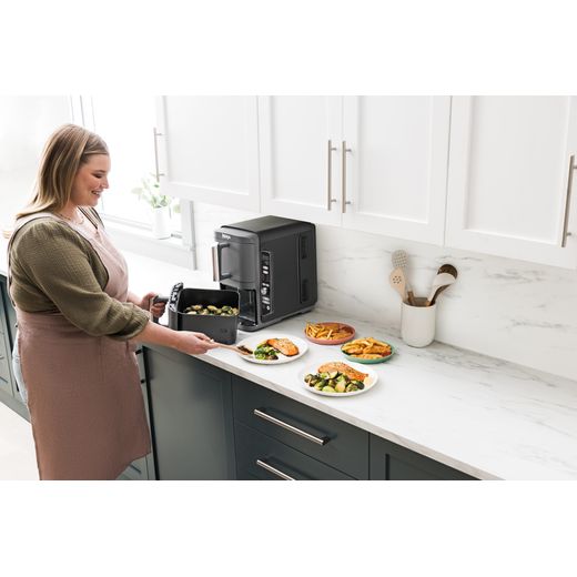 Ninja Foodi Max Dual Zone SL400UK - Black - Women cooking with air fryer in kitchen shot