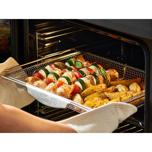 Belling Farmhouse 90E 90cm Electric Range Cooker with Ceramic Hob - Black - Person putting food in oven shot 
