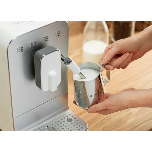 Smeg BCC12WHMUK Coffee Machines Matte White - Person using milk frother