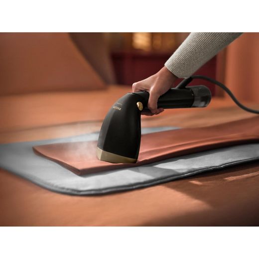 Philips 7000 series STH7060/86 Handheld Garment Steamer - Black / Gold - person using steamer shot