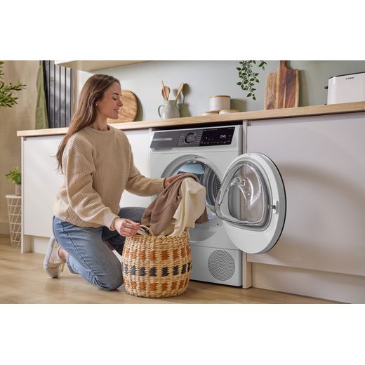 Bosch Series 6 WQH246D9GB 9Kg Heat Pump Tumble Dryer - White - women loading machine shot