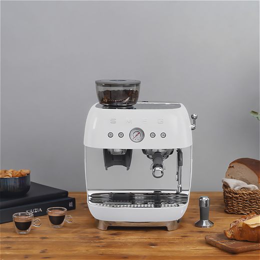 Smeg EGF03WHUK Coffee Machines White - Coffee machine on table with coffee cups at side shot