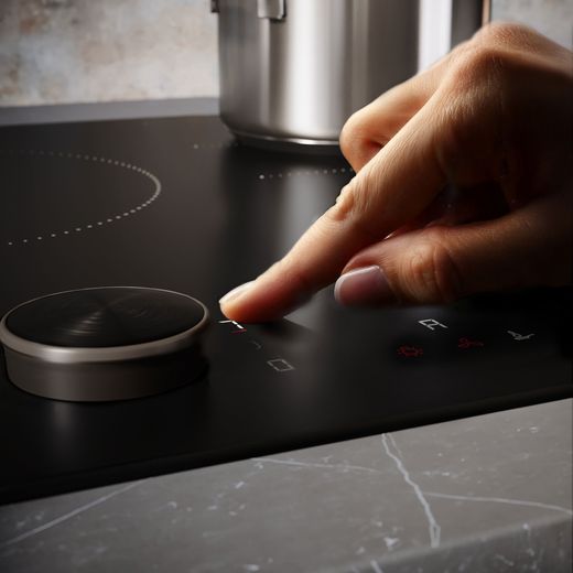NEFF N90 T68NUV4A0 80cm Induction Hob - Matt Black - person using hob shot