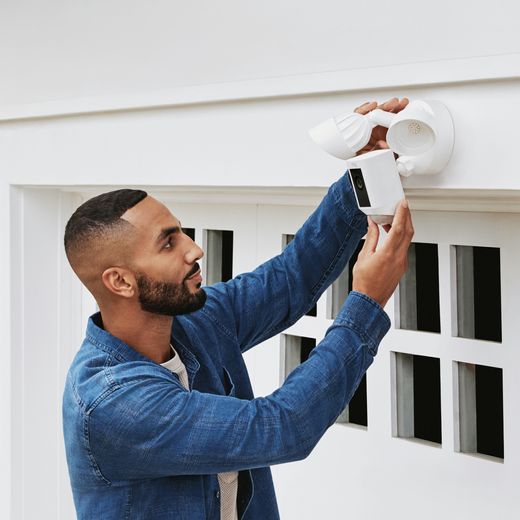 Ring Floodlight Cam Wired Plus Full HD 1080p Smart Home Security Camera - White - Man installing camera on wall shot