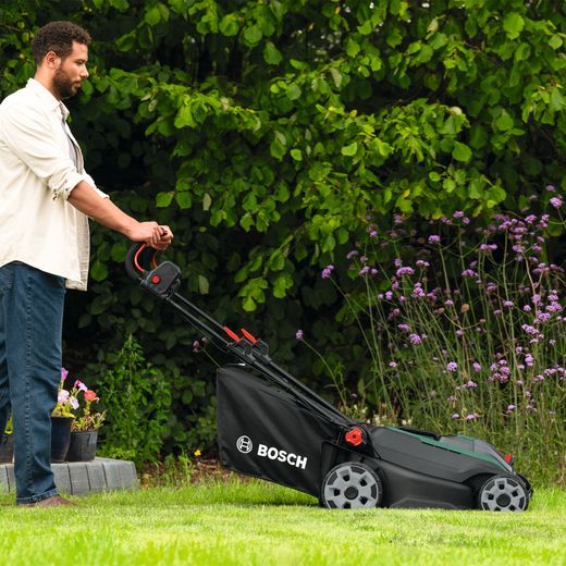 Bosch Rotak 18V2-43 Lawn Mower, Including Battery - Person mowing grass shot
