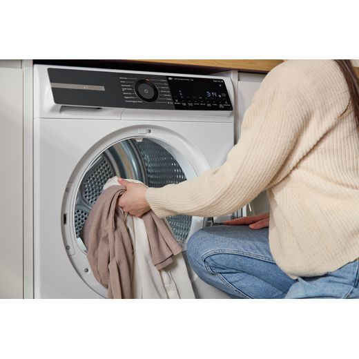 Bosch Series 6 WQH246D9GB 9Kg Heat Pump Tumble Dryer - White - person loading drum shot