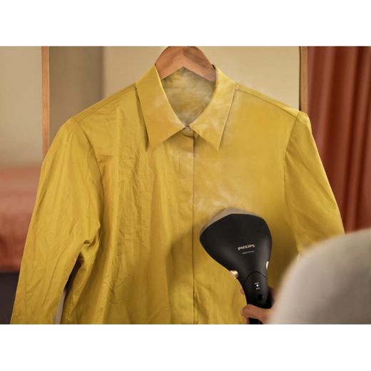 Philips 7000 series STH7060/86 Handheld Garment Steamer - Black / Gold - person steaming top shot