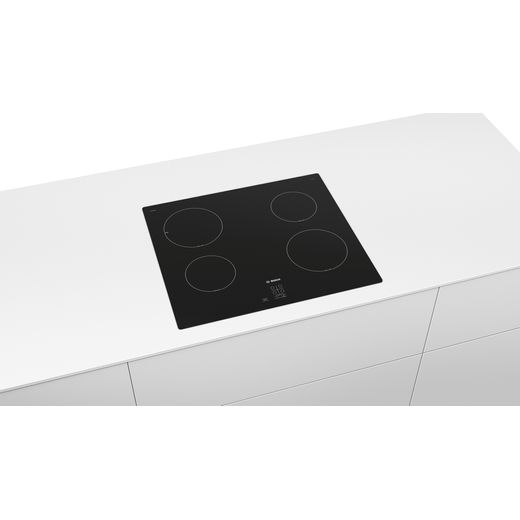 Bosch Serie 2 PUG61RAA5B 59cm Induction Hob - Black - Aerial view of the hob in a white worktop